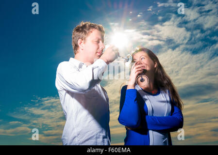 Junges Paar Rotwein trinken gegen den Himmel geschossen Stockfoto
