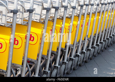 Reihe von Flughafen Gepäckwagen Stockfoto