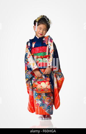 Eine süße junge japanische Mädchen trägt einen Kimono auf weißem Hintergrund. Stockfoto