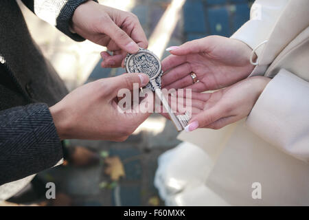 Bräutigam gibt der Braut einen Schlüssel Stockfoto