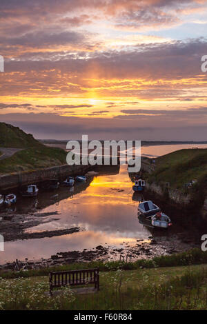 Blick auf den Sonnenuntergang Seaton Schleuse Hafen und den Strand und die Dünen von Blyth über Tyne and Wear und Northumberland UK Stockfoto