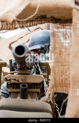 Zweiten Weltkrieg Re-enactment. Nahaufnahme von deutschen Soldaten Ziel mit schweren Maschinengewehr MG 42, in befestigten gegraben. Stockfoto