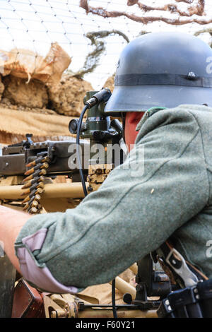 Zweiten Weltkrieg Re-enactment. Nahaufnahme von deutschen Soldaten Ziel mit schweren Maschinengewehr MG 42, in befestigten gegraben. Stockfoto