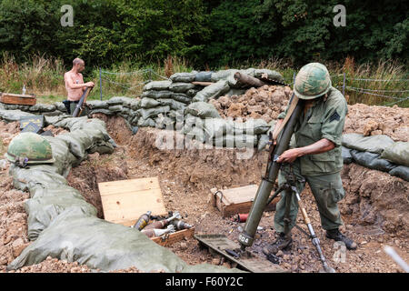 Vietnamkrieg Rolling Thunder Re-enactment-Gruppe. Marine, US-Soldat, in sandbagged verschanzt Schussposition, Einrichten von schweren Trench mortar. Stockfoto