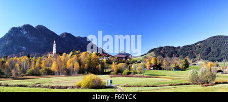 Blick auf die herbstliche Landschaft bei Pfronten, Bayern, Deutschland in schönstem Herbstwetter mit der Kirche St. Nikolaus in der front Stockfoto