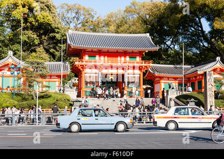 Japan, Kyoto. Wahrzeichen, die Vermillion Romon, zweigeschossigen Muromachi Periode Torhaus zum Yasaka Schrein im Sonnenschein. Taxis vorbei vor. Stockfoto