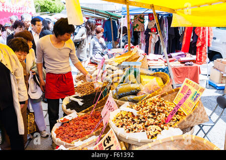 Japan, Kyoto, Kobo-san Monatlichen Markt im Freien an der Koji Tempel. Kunden und Händler vor der Körbe mit getrockneten Früchten auf Abschaltdruck gefüllt. Stockfoto