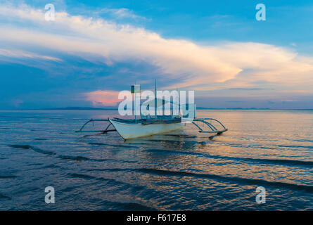 traditionelle Bangka Boot am philippinischen Strand bei Sonnenuntergang Stockfoto