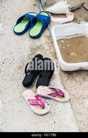 In der Nähe des Eingang zu einem karibischen Strand in St. Croix, Amerikanische Jungferninseln, Flip-Flops oder Badeschuhe aufgereiht. Konzeptionelle Stockfoto