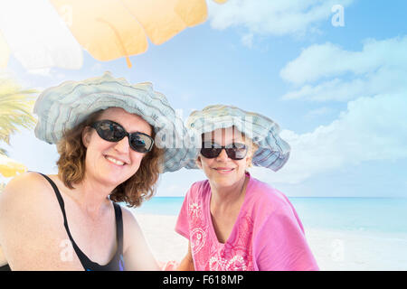 Zwei mittleren Alters kaukasischen Frauen Lächeln in die Kamera an einem karibischen Strand in St. Croix, Amerikanische Jungferninseln. High-Key. USVI, U.S.V.I. Stockfoto