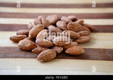 Eine Handvoll Mandeln auf ein Schneidebrett zu einem gesunden nahrhaften Snack bereit. Stockfoto