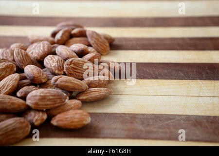 Eine Handvoll Mandeln auf ein Schneidebrett zu einem gesunden nahrhaften Snack bereit. Stockfoto