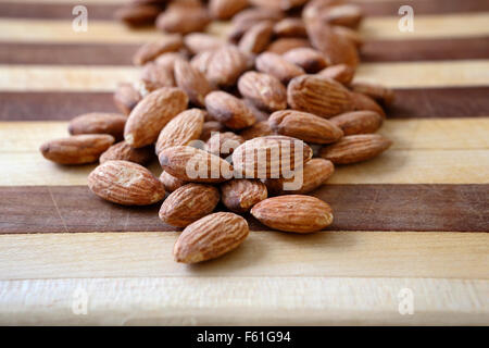 Eine Handvoll Mandeln auf ein Schneidebrett zu einem gesunden nahrhaften Snack bereit. Stockfoto