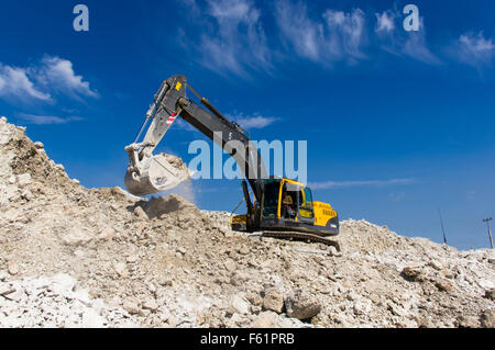 Bagger arbeiten in einem Steinbruch Ton an einem sonnigen Tag Stockfoto