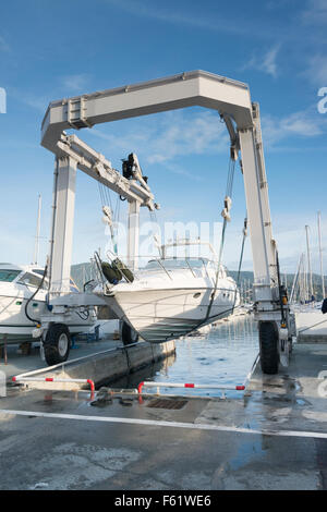 Ein Ausflugsschiff aus dem Hafen von einem Bootskran in Cavalaire Frankreich aufgehoben wird Stockfoto