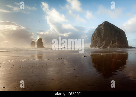 Dramatisches Licht und Himmel am Haystack Rock an der Küste Oregons. Haystack Rock ist ein 235-Fuß Meer Stapel in Cannon Beach, Oregon Stockfoto