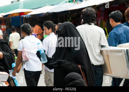 Eine komplett überdachte arabischen Touristen auf dem Chatuchak-Markt in Bangkok. Stockfoto