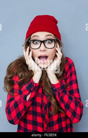 Porträt von erstaunt Hipster Frau Blick in die Kamera über den grauen Hintergrund Stockfoto