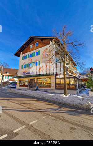 GARMISCH-PARTENKIRCHEN, Deutschland-6. Januar 2015: Blick auf das Haus in Garmisch-Partenkirchen mit leuchtend grünen Fensterläden und liebevoll Gemälde an der Wand. Stockfoto