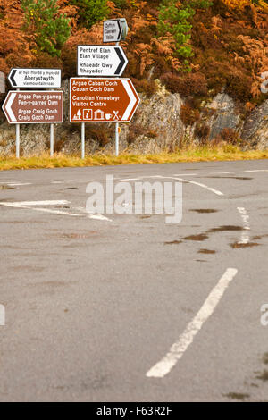 Verkehrsschilder an der Kreuzung am Garreg DDU Dam, Elan Valley, Powys, Mid Wales, Großbritannien im November mit Herbstfarben Stockfoto