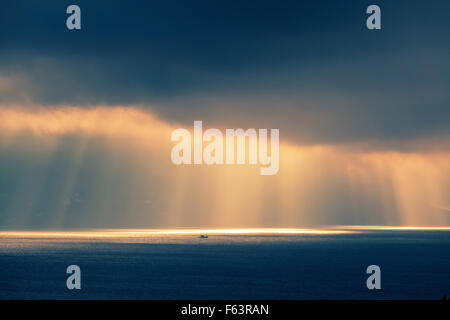 Atlantischen Ozean Landschaft Abend Sonne durchläuft dunkel bewölkter Himmel. Retro-Stil, bunte Tonwertkorrektur Foto Filter eff Stockfoto