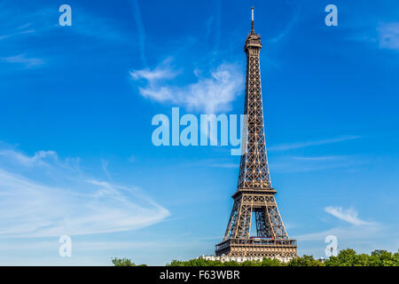 Eiffelturm vor einem blauen Himmel mit Wolkenfetzen. Stockfoto