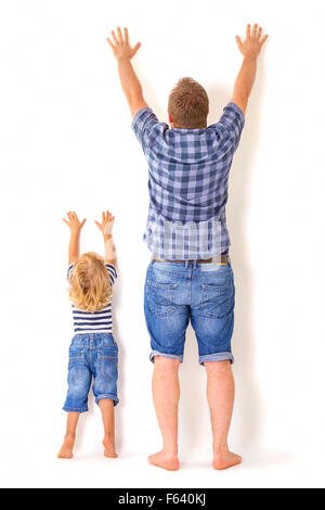 Vater und Sohn stehen mit dem Rücken zur Kamera mit Händen. Aufwachsen, Konzept. Stockfoto