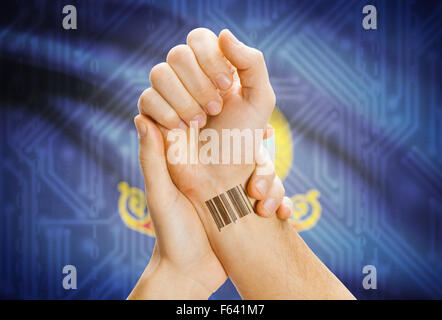 Barcode-ID Nummer Tatoo am Handgelenk und USA Statesl Flagge auf Hintergrund - Idaho Stockfoto