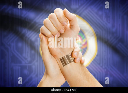 Barcode-ID Nummer Tatoo am Handgelenk und USA Statesl Flagge auf Hintergrund - Minnesota Stockfoto