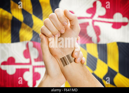 Barcode-ID Nummer Tatoo am Handgelenk und USA Statesl Flagge auf Hintergrund - Maryland Stockfoto