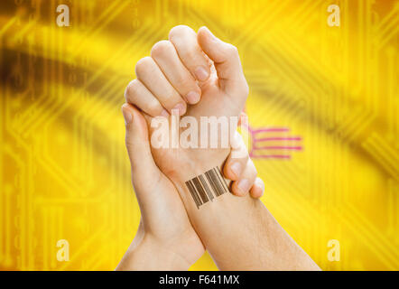 Barcode-ID Nummer Tatoo am Handgelenk und USA Statesl Flagge auf Hintergrund - New Mexico Stockfoto