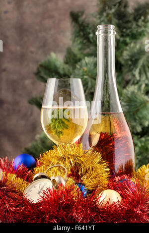 Weihnachten-Stillleben mit Champagner und Dekorationen am Weihnachtsbaum vor verschwommenen Hintergrund Stockfoto