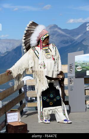 Ein Mann gekleidet in indigene indische zeremonielle Tracht posiert für Fotos auf Sulphur Mountain, Banff, Alberta, Kanada Stockfoto