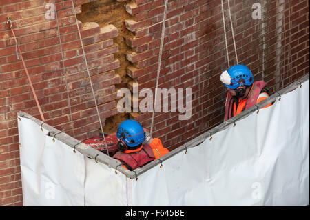 London, UK. 11. November 2015.  Bauarbeiter bei Arbeiten auf einem Backstein unterstützt unter Hungerford Bridge.  Sie stehen auf einer speziell schwebenden Plattform mit der Themse ein paar Füße darunter und Schienen in Charing Cross Bahnhof über ihnen. Bildnachweis: Stephen Chung / Alamy Live News Stockfoto