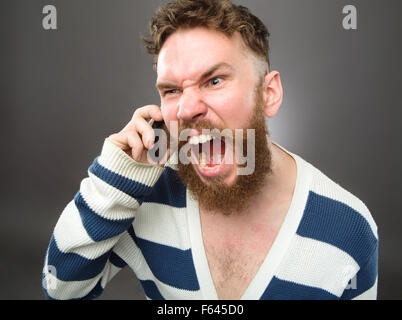 Schreiende Bart Mann Porträt mit Handy-Studio schwarz-Hintergrund Stockfoto