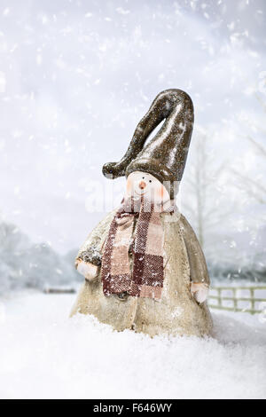 Schneemann im Feldweg mit Schnee fällt Stockfoto