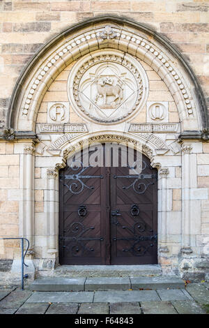 Große hölzerne Tür mit einem Griff, Schmiedeeisen Griff. Die Tür in den Tresor aus Sandstein. Stockfoto