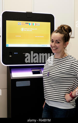 lächelnde junge Frau mit einem digitalen Währung Bitcoin atm England uk Stockfoto