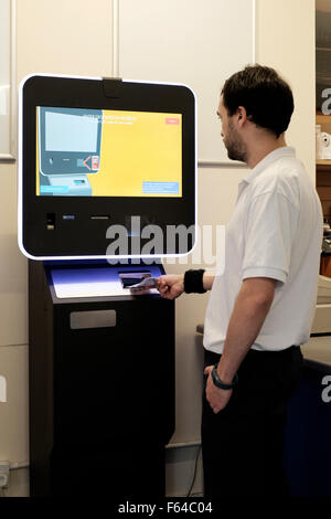 junger Mann mit einem digitalen Währung Bitcoin atm England uk Stockfoto