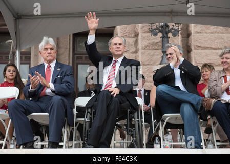 Austin, Texas USA 11. November 2015: Texas Gouverneur Greg Abbott winkt der Capitol Masse während der Veteran Tagesparade Congress Avenue und Zeremonie auf dem Texas Kapitol. Mehrere tausend Texaner ausgekleidet Congress Avenue um Kriegshelden, marching Bands und schwimmt in die jährliche Parade beizuwohnen. Auf der linken Seite ist Kongressabgeordnete Roger Williams und Austin Bürgermeister Steve Adler ist auf der rechten Seite. Bildnachweis: Bob Dämmrich/Alamy Live-Nachrichten Stockfoto