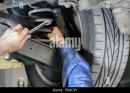 Hände-Mechanik, die Suspension auf das Auto zu reparieren Stockfoto
