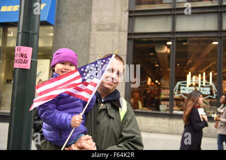 New York City, USA. 10. November 2015. Kleines Mädchen Uhren Parade mit US-Flagge. New York Citys Veterans Day wurde von der US Navy als das diesjährige Top Service und grand Marshal und Weltkrieg zwei Marine-Veteran Robert Morgenthau geführt. © Andy Katz/Pacific Press/Alamy Live-Nachrichten Stockfoto