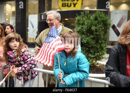 New York City, USA. 10. November 2015. Kinder sehen Parade USA Markierungsfahnen wellenartig. New York Citys Veterans Day wurde von der US Navy als das diesjährige Top Service und grand Marshal und Weltkrieg zwei Marine-Veteran Robert Morgenthau geführt. © Andy Katz/Pacific Press/Alamy Live-Nachrichten Stockfoto