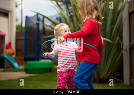 Zwei kleine Mädchen in einen Hula-Hoop-Reifen Stockfoto