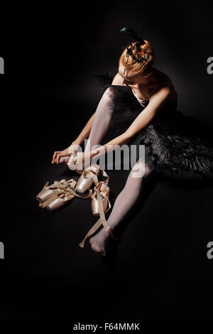 Schlanke Tänzerin in ein schwarzes Korsett und schwarzen Tutu Spitzenschuhe binden. Klassisches Ballett. Stockfoto
