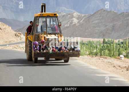 Leh, Indien - 19. Juli 2014: Frauen in Führungspositionen mit einer Erdbewegung Maschine als Transport auf der Straße in Ladakh, Indien Jammu Bestandteil & Stockfoto