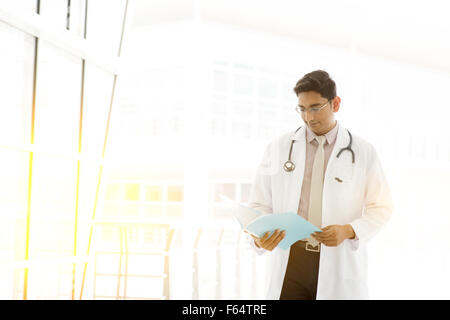 Porträt der schönen asiatischen indischen medizinischen Doktor Wandern und lesen auf medizinisches Gutachten außerhalb Krankenhaus Baustein, SC. Stockfoto