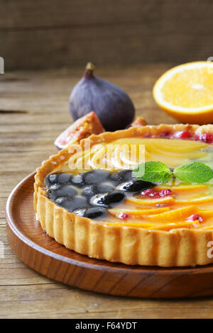 Obstkuchen mit verschiedenen Beeren (Trauben, Pfirsiche, Kiwi, Orange) Stockfoto