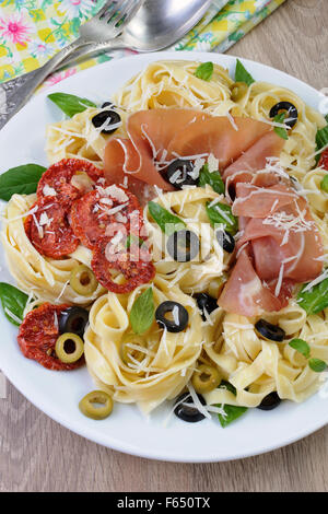 Nudeln mit Schinken, Oliven, getrockneten Tomaten und Parmesan Stockfoto