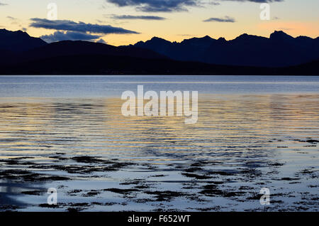 gelbe Sonnenuntergang über majestätische Bergkette und kalten blauen Fjord am Polarkreis Stockfoto